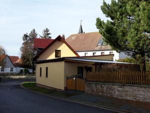 uma casa branca com uma cerca à frente. em Ferienhaus zu Wohlsborn em Wohlsborn