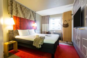 Cette chambre comprend un lit et une télévision. dans l'établissement ibis Hotel Hamburg St. Pauli Messe, à Hambourg