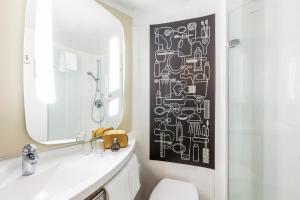 a bathroom with a black and white pattern on the wall at ibis Hotel Hamburg St. Pauli Messe in Hamburg