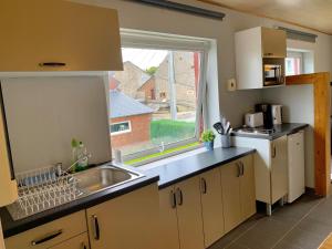 a kitchen with a sink and a large window at Appartement Vallee de la Meuse - Esc'Appart in Blaimont