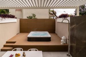 a hot tub sitting on top of a patio at Sicilia's Art Hotel & Spa in Acitrezza