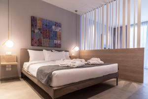 ein Schlafzimmer mit einem Bett mit zwei Handtüchern darauf in der Unterkunft Sicilia's Art Hotel & Spa in Acitrezza