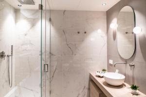 a bathroom with a glass shower and a sink at Sicilia's Art Hotel & Spa in Acitrezza