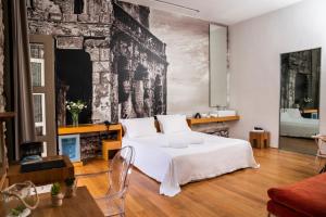 a bedroom with a white bed and a fireplace at Aire Hotel & Ancient Baths in Almería