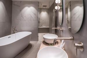 a bathroom with a large tub and a sink at Sicilia's Art Hotel & Spa in Acitrezza