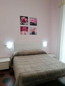 a bedroom with a bed and two pictures on the wall at Come D'Incanto A Napoli in Naples