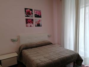ナポリにあるコム ディンカント A ナポリのベッドルーム1室(ベッド1台付)が備わります。壁に絵が飾られています。