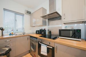 a kitchen with a microwave and a sink at Home Sweet Home by Paymán Club in Cambridge