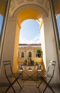 stół i krzesła na balkonie z budynkiem w obiekcie N A P Experience Apartments w mieście Napoli