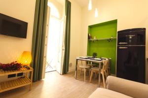 eine Küche mit einem Tisch und einer grünen Wand in der Unterkunft N A P Experience Apartments in Neapel