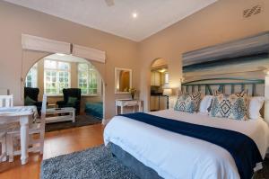 um quarto com uma cama grande e uma secretária em Margate Place Guest House em Port Elizabeth