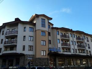 un gran edificio con coches estacionados frente a él en Studio Villa Park 207, en Borovets