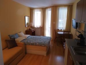 um pequeno quarto com uma cama e um sofá em Studio Villa Park 207 em Borovets