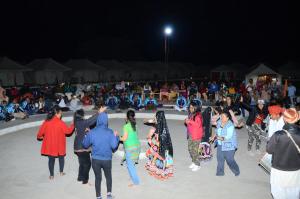 a group of people dancing in the snow at night at Dynasty Desert Camp and Resort in Sām