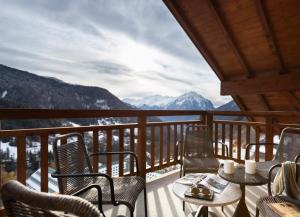 a balcony with chairs and tables and a view of mountains at TERRESENS - Le Saphir in Vaujany