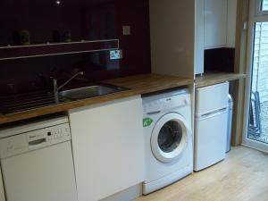 a kitchen with a washing machine and a sink at The Wee Thistle Loch Ness in Drumnadrochit