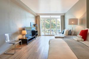 a bedroom with a large bed and a living room at Estoril BeachFront Balcony apartment in Estoril