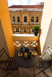 einen Tisch und Stühle auf einem Balkon mit einem Gebäude in der Unterkunft N A P Experience Apartments in Neapel