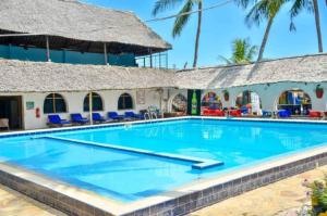 a swimming pool with a pool table and chairs at Jangwani Sea Breeze Resort in Dar es Salaam