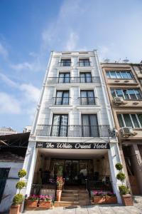un edificio de apartamentos blanco con un cartel en él en The White Orient Hotel, en Estambul