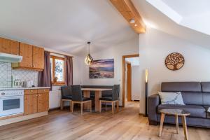 une cuisine et un salon avec une table et un canapé dans l'établissement Auschlössl Appartements - Reiteralm, à Schladming