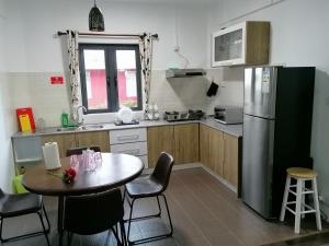 a kitchen with a table and a stainless steel refrigerator at Bobato building in Curepipe