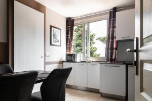 uma cozinha com armários brancos e uma janela em Villa Azur Cap d'Ail em Cap d'Ail