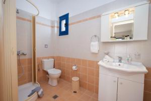 a bathroom with a toilet and a sink and a shower at Nefeli Apartments in Ayia Evfimia