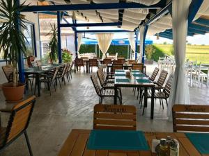 an empty restaurant with tables and chairs and tablesearcher at Orizont-Mahmudia in Mahmudia