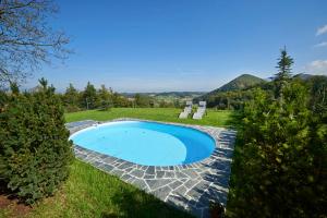 una piscina en medio de un patio con sillas en Farmhouse Lipoglav, en Loče pri Poljčanah