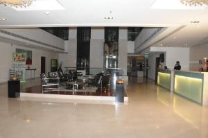 a lobby with chairs and tables in a building at Hotel Royal Park Kakinada in Kākināda
