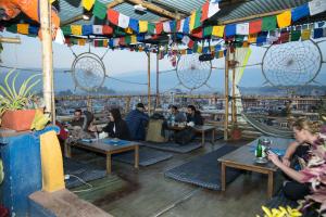 un gruppo di persone sedute ai tavoli di un ristorante di Planet Nomad Hostel a Kathmandu