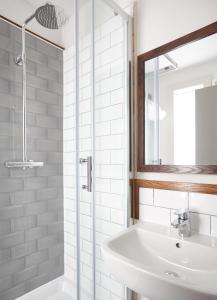 Baño blanco con lavabo y espejo en The Spyglass & Kettle by Greene King Inns, en Bournemouth