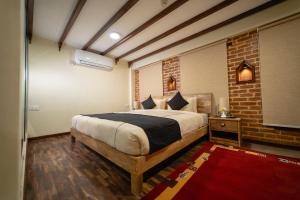a bedroom with a bed and a brick wall at Traditional Stay - A Boutique Hotel in Pātan