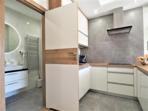 een keuken met witte kasten en een schuifdeur bij VIP Apartamenty Stara Polana 2 in Zakopane