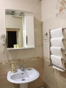 a bathroom with a sink and a mirror and towels at Guest House near Kolonnady in Kislovodsk