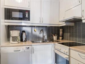 a kitchen with white cabinets and a sink at Holiday Home Vuokatinportti b 8 by Interhome in Vuokatti