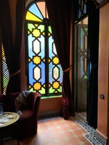 Cette chambre dispose d'un vitrail et d'une table. dans l'établissement Riad 58 Blu, à Marrakech