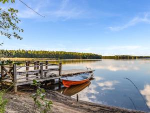 um barco está ancorado numa doca num lago em Holiday Home Villa populus by Interhome em Pertunmaa