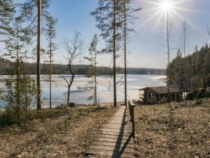 a wooden path leading to a lake with a house at Holiday Home Villa moose by Interhome in Jukara