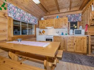 una cucina con armadi in legno e un tavolo in legno in una cabina di Holiday Home Kissaniemi by Interhome a Iisalmi