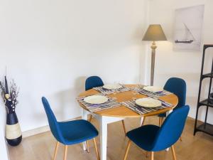 une table à manger avec des chaises bleues et une lampe dans l'établissement Apartment Le Clos tranquille by Interhome, à Nice