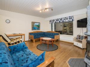 Holiday Home Oriaho by Interhome في إيسلمي: غرفة معيشة مع أريكة زرقاء وتلفزيون