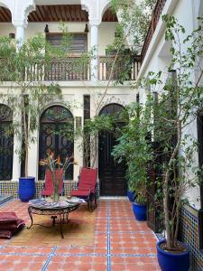 a patio with red chairs and a table in front of a building at Riad 58 Blu in Marrakesh