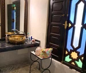 a bathroom with a sink and a mirror and a table at Riad 58 Blu in Marrakesh