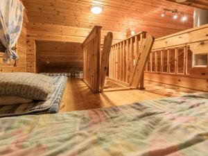 sypialnia z łóżkiem i klatką schodową w drewnianym domku w obiekcie Holiday Home Käenpesä by Interhome w mieście Iisalmi