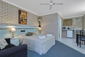 1 dormitorio con 1 cama y sala de estar en Cara Motel en Maryborough