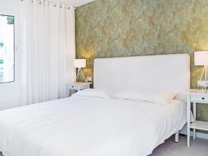 1 dormitorio con 1 cama blanca grande y 2 mesas en Apartment Pueblo Arabesque, en Marbella