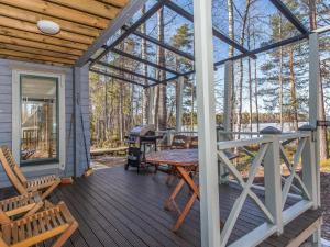a screened in porch with a wooden table and chairs at Holiday Home Villa populus by Interhome in Pertunmaa +16 photos