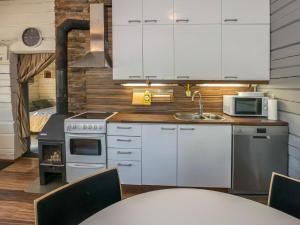 a kitchen with white cabinets and a stove at Holiday Home Jarsala by Interhome in Töfsala